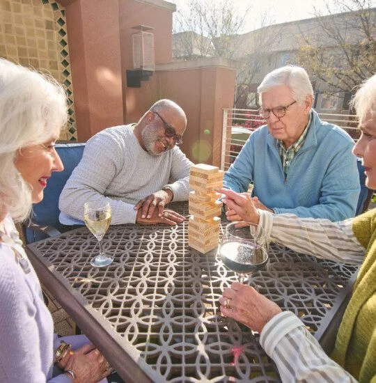 Four adults playing a game on a table