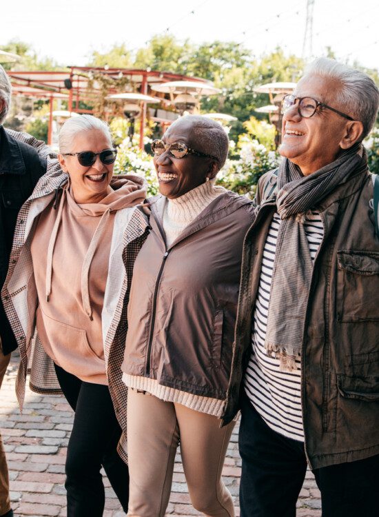 well-dressed group of senior friends walk around a scenic downtown district