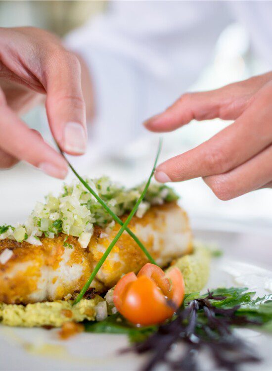close-up of chef carefully plating elegant meal
