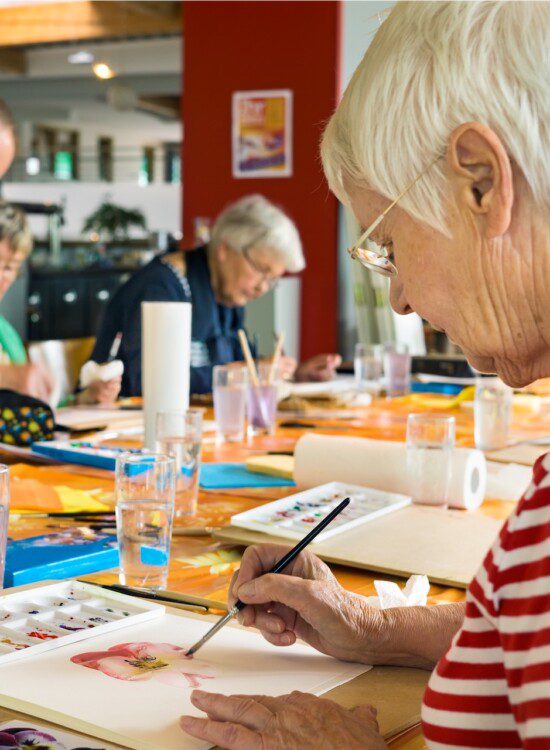 group of seniors paint watercolors during class