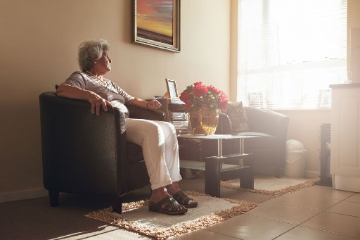 elderly woman sitting in a private senior apartment