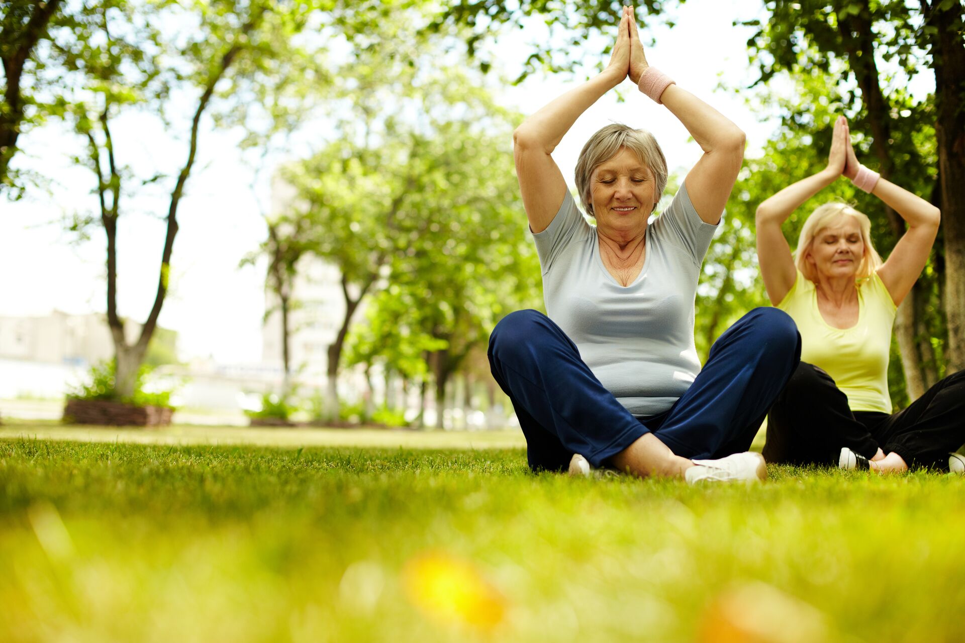 Senior women practicing yoga in the park 