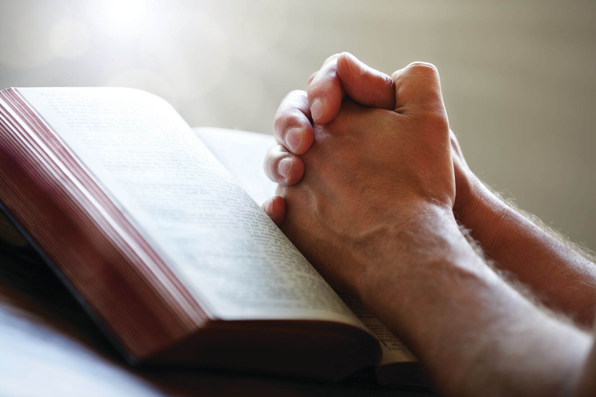 Senior praying over a book