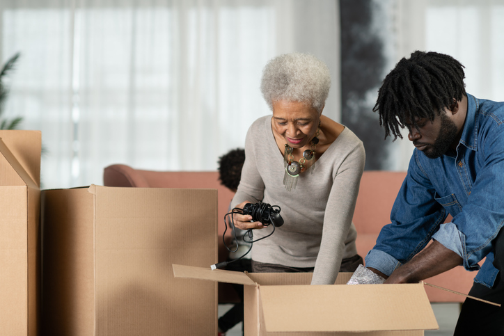 senior woman and her adult son pack her belongings for a move to a senior living community