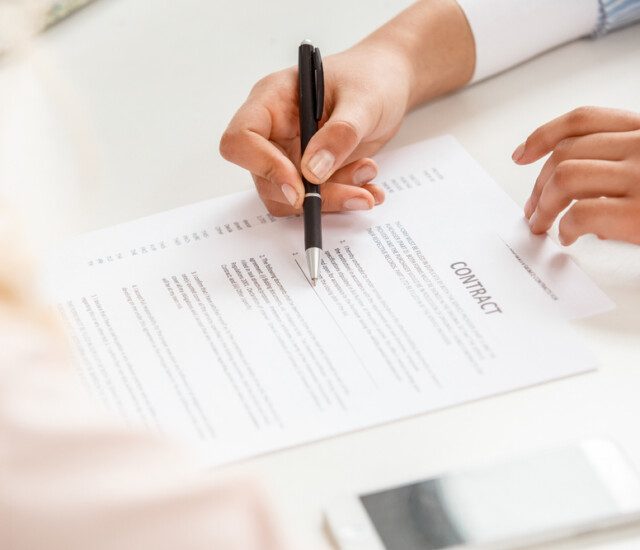 close-up of financial advisor explaining the details of a contract to a senior woman