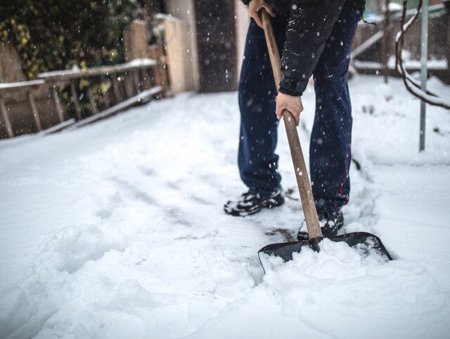 close-up of senior man shoveling snow