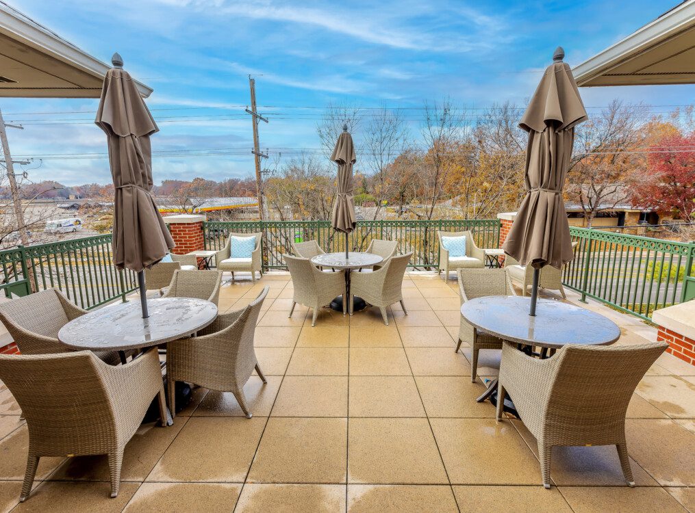 spacious patio with umbrella-equipped tables at Claridge Court Senior Living Community