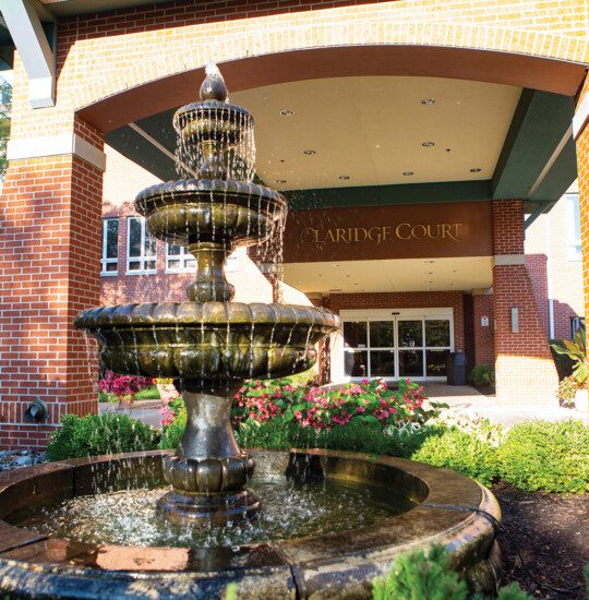 close-up of the fountain and beautiful landscaping in front of the entrance at Claridge Court Senior Living Community