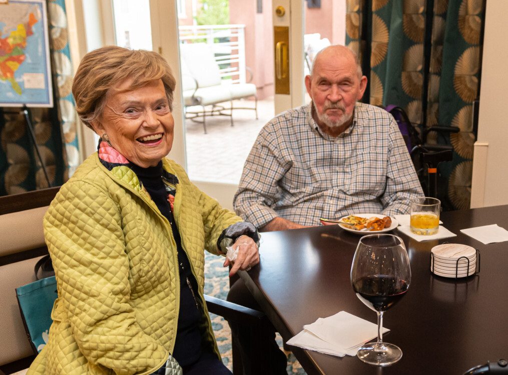 senior couple enjoys elegant dinner with wine at Claridge Court Senior Living Community