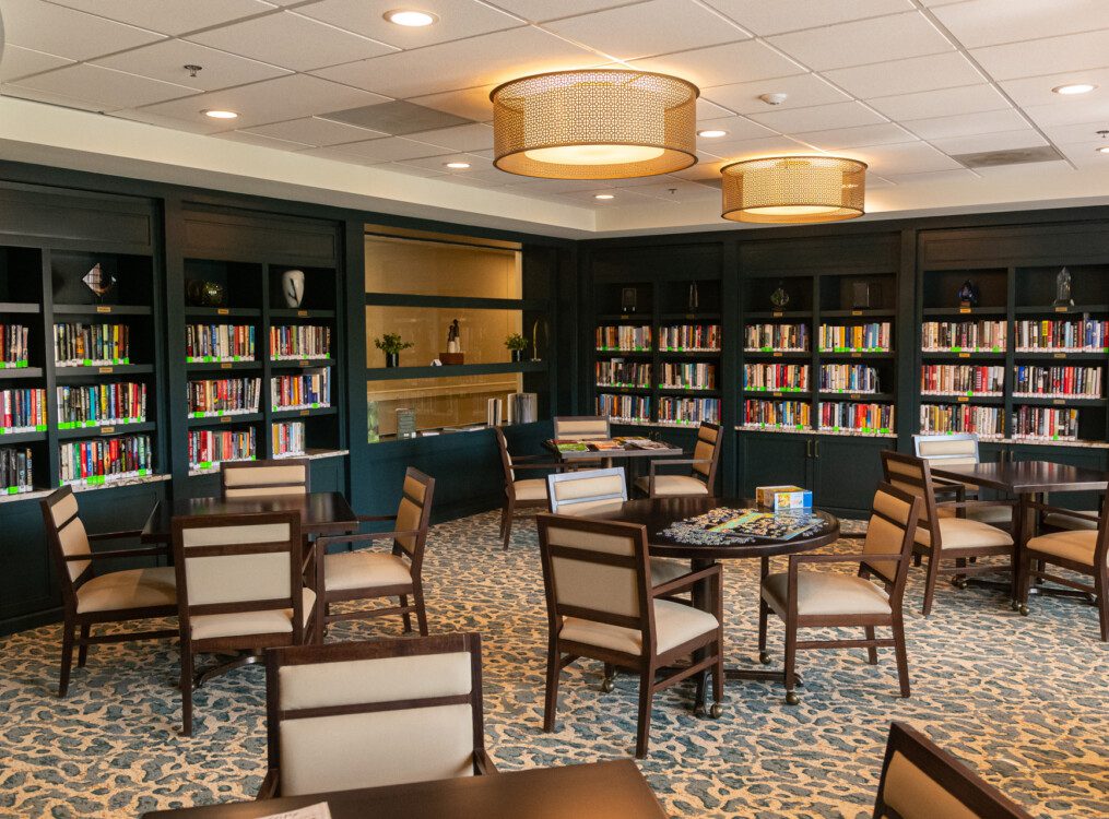 Library and lounge area with ample tables and games at Claridge Court Senior Living Community