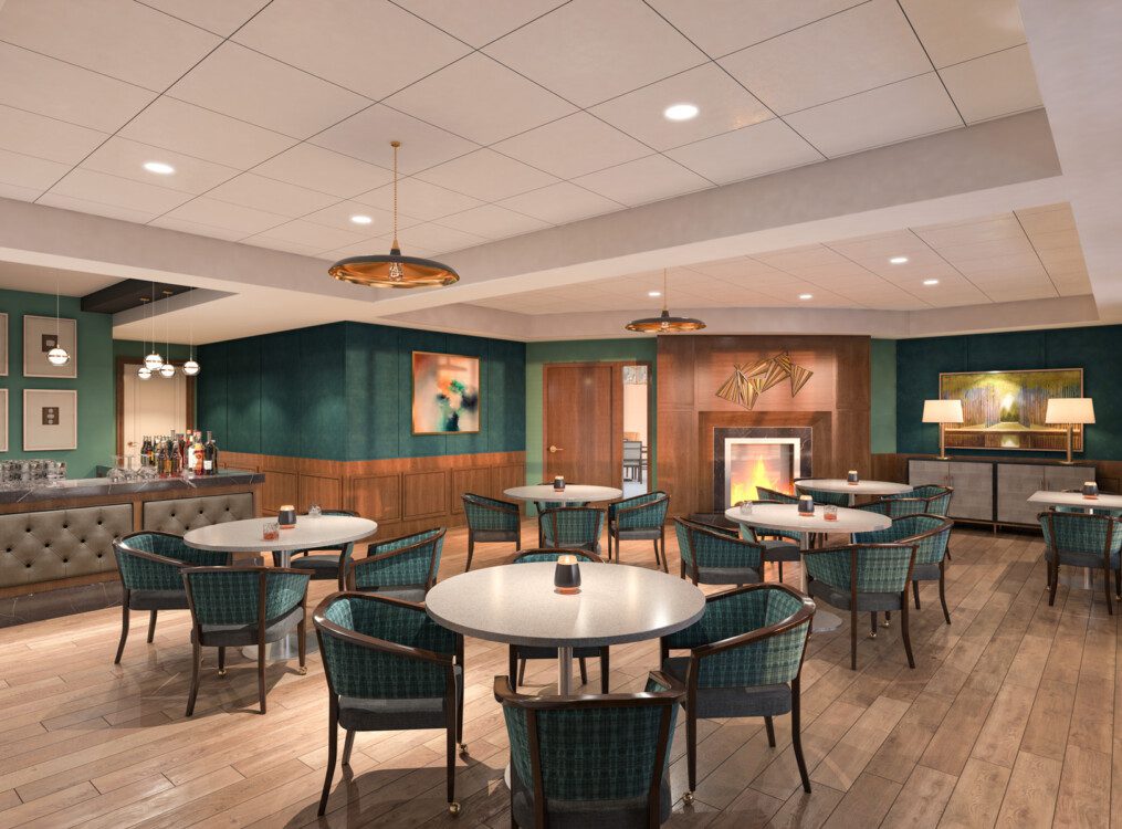 Swanky pub area with tables, bar, and fireplace at Claridge Court Senior Living Community