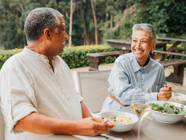 Senior couple sitting at a table, dining together.