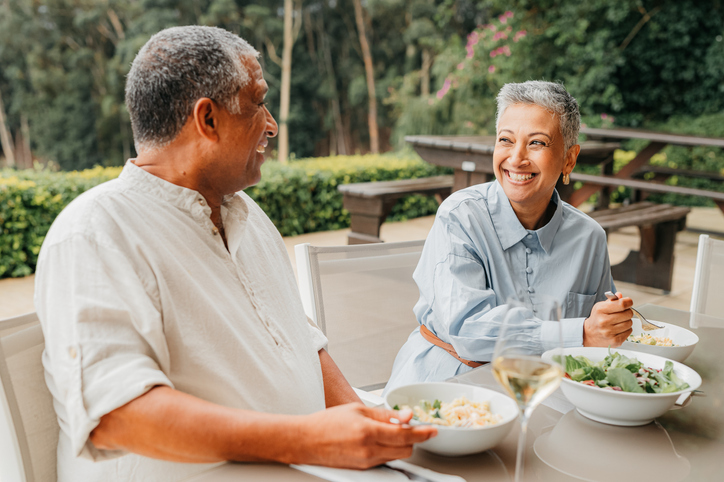 Senior couple sitting at a table, dining together.