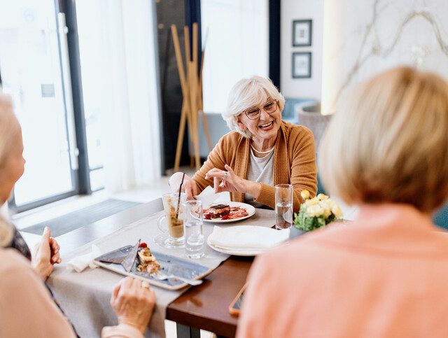 Senior women talking while having dessert