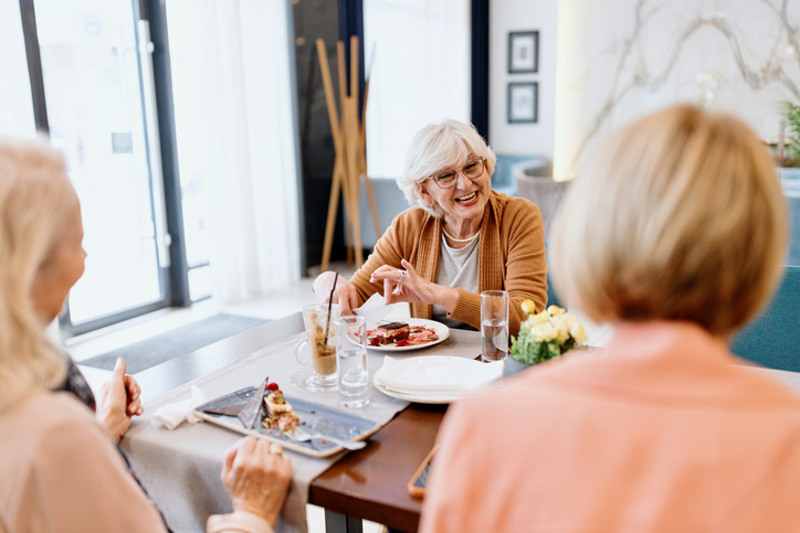 Senior women talking while having dessert